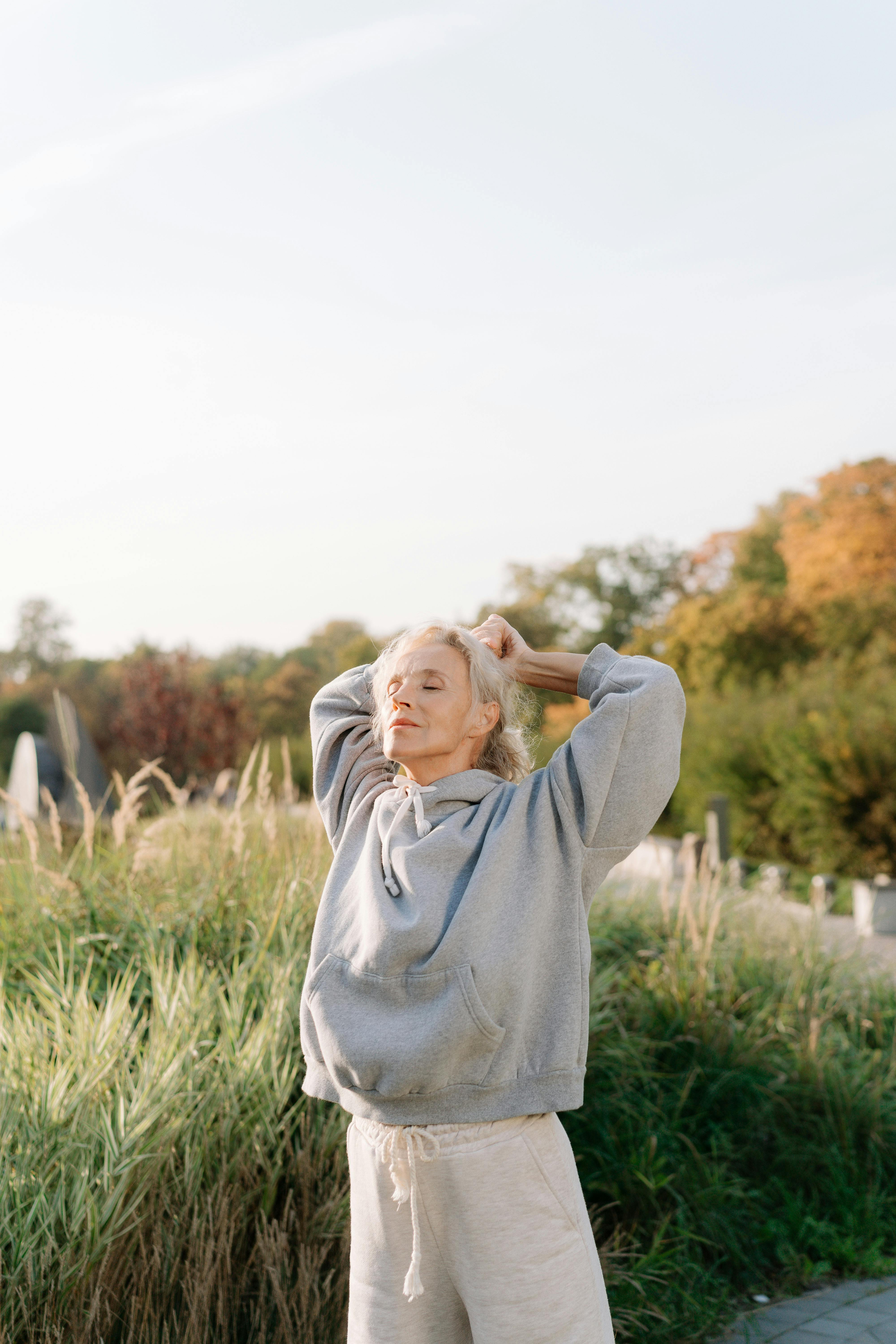 Woman standing in a sunny field.